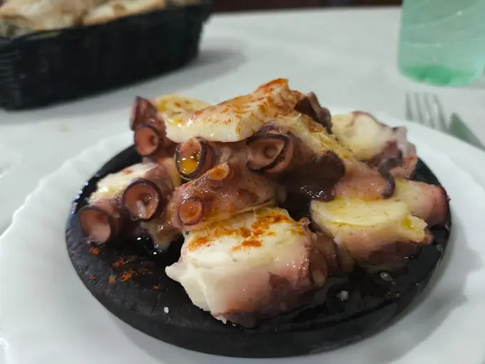 Pulpo á feira servido en plato de madeira